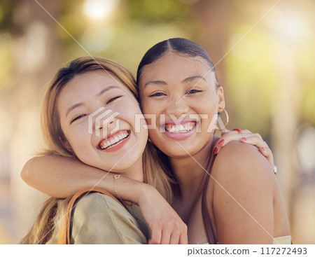 Asian, women friends and happy portrait in outdoor sunshine with embrace, hug and smile in summer. Diversity, best friends and happiness in metro together on vacation in Jakarta 117272493