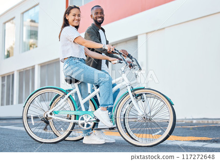 Happy couple, bicycle and city street travel for exercise, fun or adventure outdoor. Black and asian tourist man and woman cycling for carbon footprint on bike in urban town traveling in South Africa Happy couple, bicycle and city street travel for exercise, fun or adventure outdoor. Black and asian tourist man and woman cycling for carbon footprint on bike in urban town traveling in South Africa 117272648