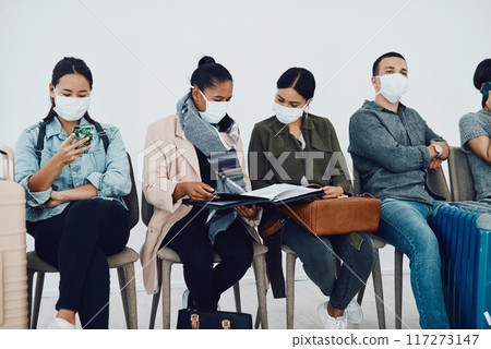 Immigration during covid with people traveling and waiting at an airport lounge during the pandemic. Foreign refugees in a public travel facility or border wearing masks in a corona virus outbreak Immigration during covid with people traveling and waiting at an airport lounge during the pandemic. Foreign refugees in a public travel facility or border wearing masks in a corona virus outbreak 117273147