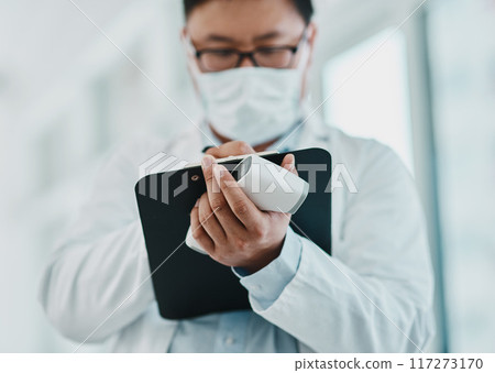 Covid, pandemic and virus, doctor or medical healthcare worker writing on a clipboard. Scientist wearing a mask to prevent the spread of the sickness and keep a checklist of infected patients 117273170