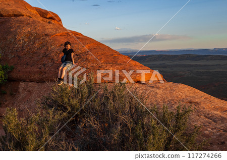 Boy Hiking at Sunset on Devils Garden Trail, Utah 117274266