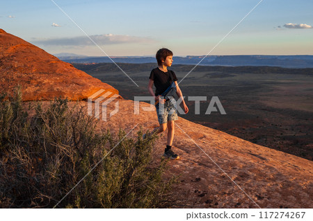 Boy Hiking at Sunset on Devils Garden Trail, Utah 117274267
