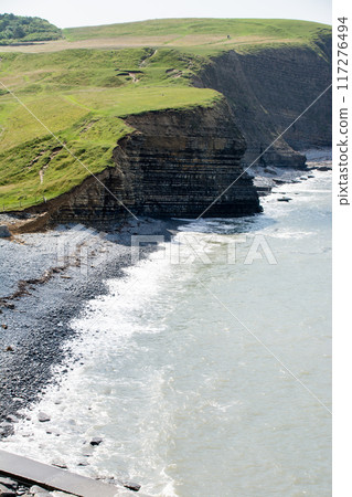 A coastline of gravel and a cove with cliffs formed by seawater erosion. On the outskirts of South Wales. 117276494