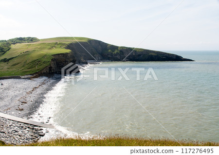 A coastline of gravel and a cove with cliffs formed by seawater erosion. On the outskirts of South Wales. 117276495