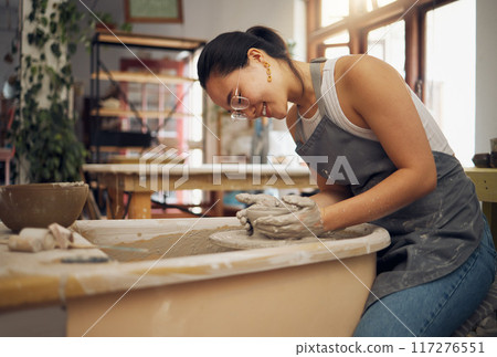 Pottery wheel, workshop and startup business woman manufacturing creative art product with hands. Happy asian potter artist working in clay or ceramics retail industry, studio or class with pride Pottery wheel, workshop and startup business woman manufacturing creative art product with hands. Happy asian potter artist working in clay or ceramics retail industry, studio or class with pride 117276551