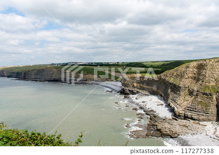 A coastline of gravel and a cove with cliffs formed by seawater erosion. On the outskirts of South Wales. A coastline of gravel and a cove with cliffs formed by seawater erosion. On the outskirts of South Wales. 117277338