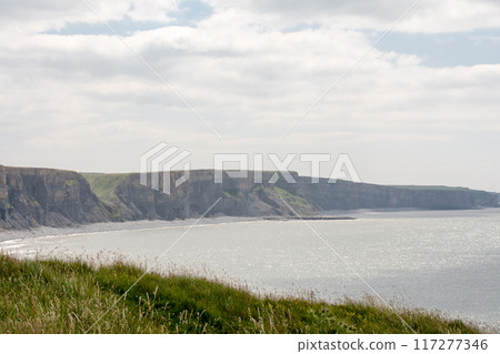 A coastline of gravel and a cove with cliffs formed by seawater erosion. On the outskirts of South Wales. 117277346
