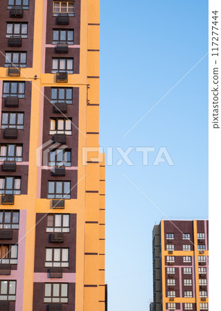 Tall apartment building with a lot of windows and balcony. 117277444