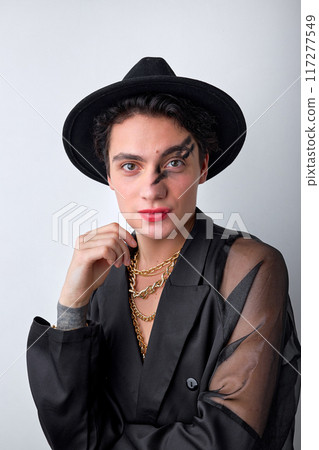 Sexy man in black translucent shirt and hat, with make-up posing at camera, isolated Sexy man in black translucent shirt and hat, with make-up posing at camera, isolated 117277549