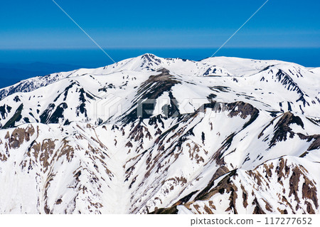Climbing Mount Yari in the Northern Alps in early summer with snow remaining on the mountain. The view from the summit of Mount Yari. Mount Sugoroku and Mount Kurobegoro. Climbing Mount Yari in the Northern Alps in early summer with snow remaining on the mountain. The view from the summit of Mount Yari. Mount Sugoroku and Mount Kurobegoro. 117277652
