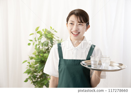 Smiling female cafe staff bringing cold drinks 117278660