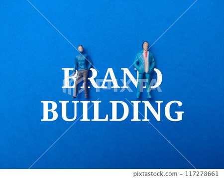 Miniature people with text BRAND BUILDING on a blue background. Miniature people with text BRAND BUILDING on a blue background. 117278661