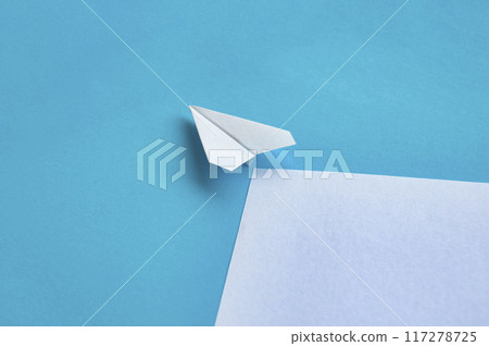Angle view of paper airplane flying on blue background with customizable space for text Angle view of paper airplane flying on blue background with customizable space for text 117278725