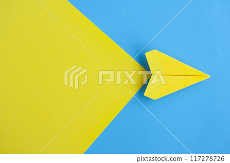Top view of yellow paper airplane flying on blue background with customizable space for text Top view of yellow paper airplane flying on blue background with customizable space for text 117278726