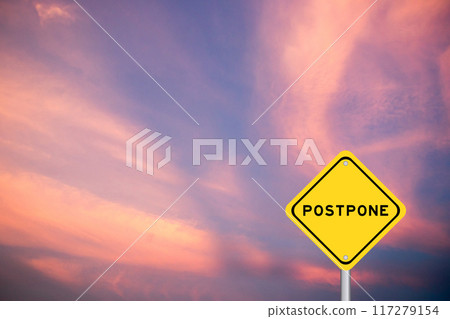 Yellow transportation sign with word postpone on violet color sky background Yellow transportation sign with word postpone on violet color sky background 117279154