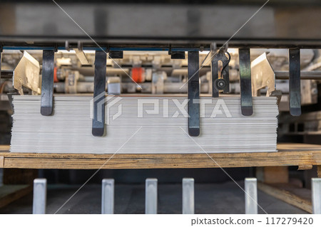 Printed sheets of paper are served in the printing press Printed sheets of paper are served in the printing press 117279420