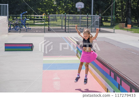 A little cute stylish girl jumping in a city skate park 117279433