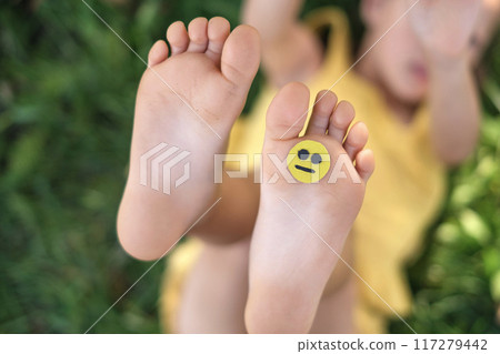 A sad little smile face on a child's foot. A sad little smile face on a child's foot. 117279442