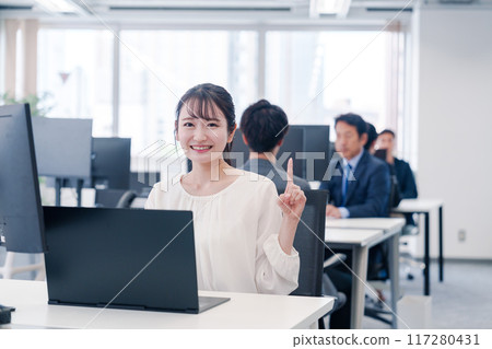 年輕的女商人在辦公室的辦公桌前工作時指著 117280431