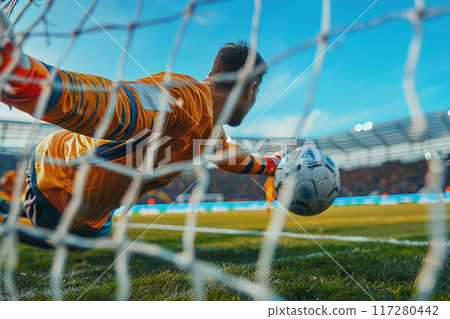 A soccer team goalkeeper in a championship sports game jumps against the goal net for the ball. 117280442