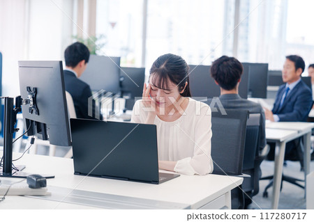 Businesswoman tired from long hours of desk work 117280717