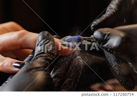 Manicurist doing hardware manicure to female client using special tools Manicurist doing hardware manicure to female client using special tools 117280754