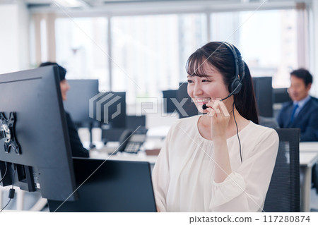 Young businesswoman speaking with a headset Young businesswoman speaking with a headset 117280874