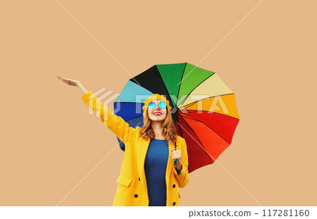 Autumn color outfit, beautiful happy cheerful young woman holds colorful umbrella enjoys new season 117281160
