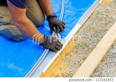 Worker is assembling an metal frame for at above ground pool Worker is assembling an metal frame for at above ground pool 117281853