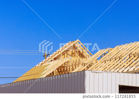 Frame installation of wooden roofing trusses to house under construction 117281855