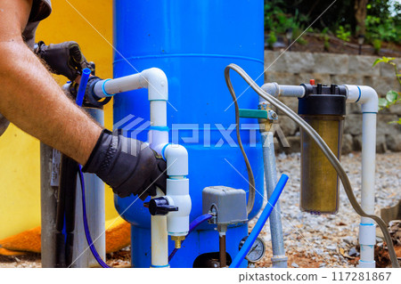 An artesian well system pump house is being connected to PVC water pipe 117281867