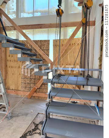 An installation of metal support stairs to second floor is underway in new building 117281875