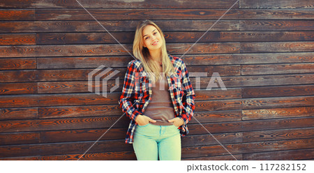 Portrait of beautiful caucasian blonde young woman in casual checkered shirt in the city 117282152
