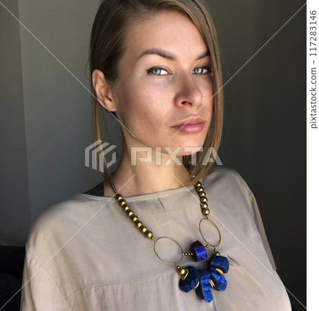Portrait of a young woman in unusual massive jewelry Portrait of a young woman in unusual massive jewelry 117283146