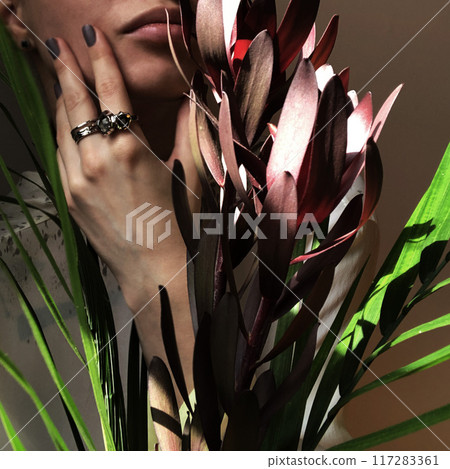 Female hand with silver rings holds a bouquet of flowers 117283361