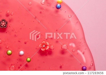 Colorful gel texture, clear skincare cream with bubbles and decorative figurines background, transparent beauty serum, colored cosmetic product close up Colorful gel texture, clear skincare cream with bubbles and decorative figurines background, transparent beauty serum, colored cosmetic product close up 117283656