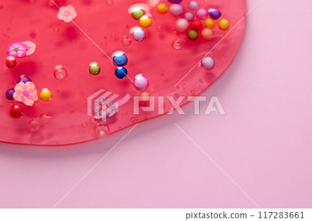 Colorful gel texture, clear skincare cream with bubbles and decorative figurines background, transparent beauty serum, colored cosmetic product close up 117283661