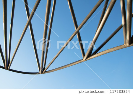 Abstract metal figure on a colorful pink background, artistically welded metal pipes, fragment of scaffolding in NYC 117283834