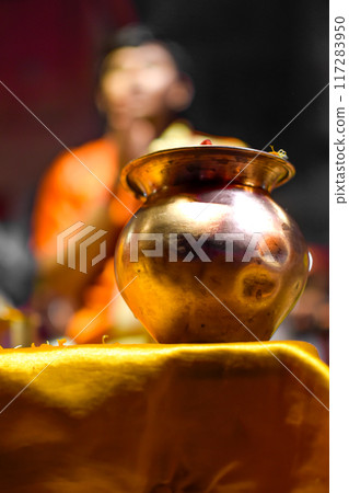 Close up image Bowl of Aarti ceremony with Pujari or Indian priest in background 117283950