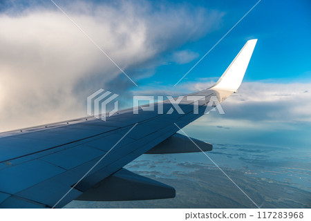 Aircraft flying in sunset. Clouds and a wing of airbus from the airplane window Aircraft flying in sunset. Clouds and a wing of airbus from the airplane window 117283968