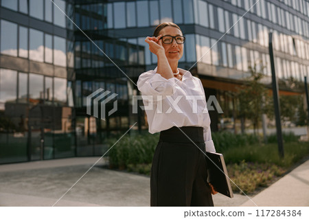 A confident, ambitious businesswoman in a modern office, exuding professionalism and drive A confident, ambitious businesswoman in a modern office, exuding professionalism and drive 117284384