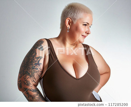 Confident Plus-Size Woman in Swimsuit against White Studio Background 117285200