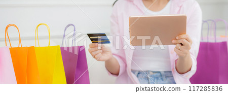 Young asian woman sitting on sofa using digital tablet shopping online with credit card. Young asian woman sitting on sofa using digital tablet shopping online with credit card. 117285836
