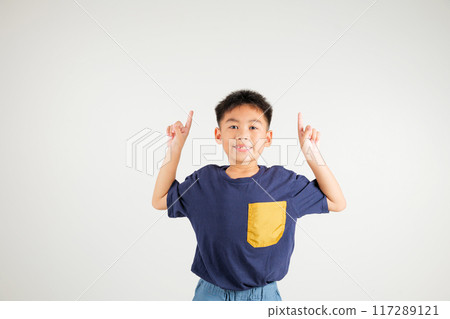 Asian happy portrait cute young kid boy makes gesture fingers point upwards above presenting product something, studio shot isolated on white background, primary children man smile Asian happy portrait cute young kid boy makes gesture fingers point upwards above presenting product something, studio shot isolated on white background, primary children man smile 117289121