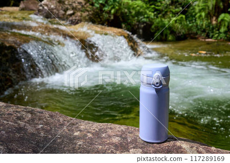 [Chiiwa Gorge] A water bottle placed on the riverbank of a summer stream 117289169