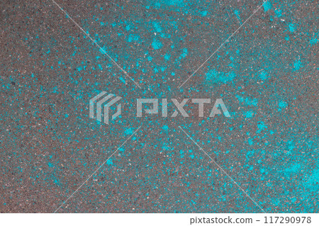 Multicolored dry blue paints on gray asphalt. Powder coating at the Holi festival. Place for inscription. 117290978