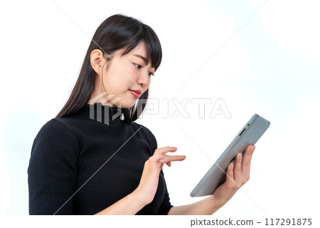 Young woman sitting with a tablet Young woman sitting with a tablet 117291875