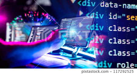 Programmer manually working with program code on a computer at night in a data center 117292525