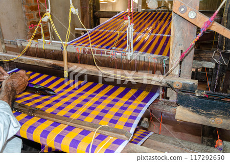 Cotton weaving on a traditional wooden handloom Cotton weaving on a traditional wooden handloom 117292650