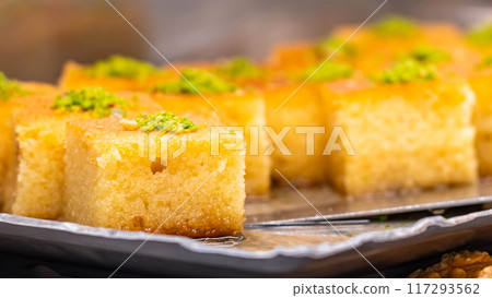 Pieces of cake made from semolina with pistachio decoration and honey 117293562